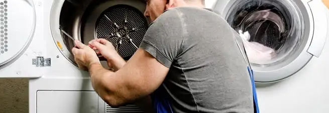 Dryer repair technician fixing a clothes dryer drum in Worcester, MA