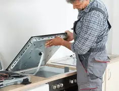 Appliance repair technician installing a built-in cooktop in Worcester, MA