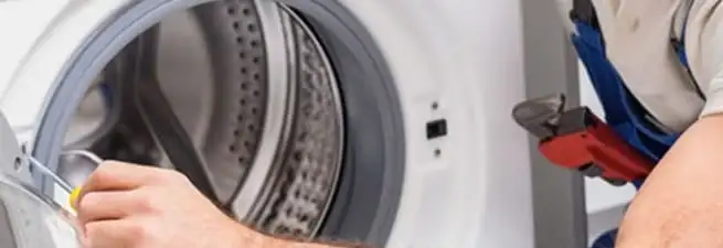 Appliance technician repairing a clothes dryer drum and internal parts in Worcester, MA
