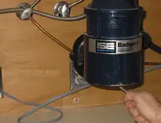 Garbage disposal repair technician tightening the mounting ring under a sink in Worcester, MA