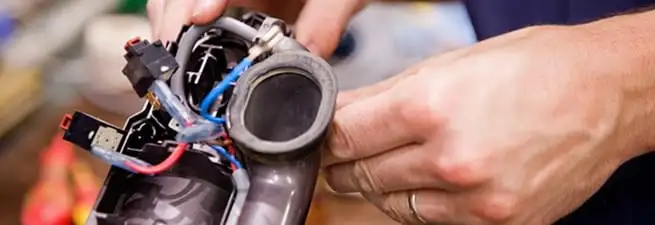 Vacuum repair technician reconnecting wiring and components in Worcester, MA