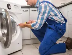 Washing machine repair technician servicing a front-load washer in Worcester, MA