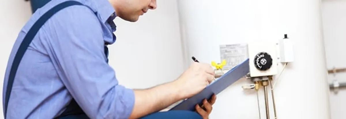 Water heater repair technician inspecting the unit and recording service notes in Worcester, MA