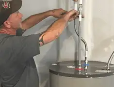 Water heater repair technician tightening supply line connections in Worcester, MA